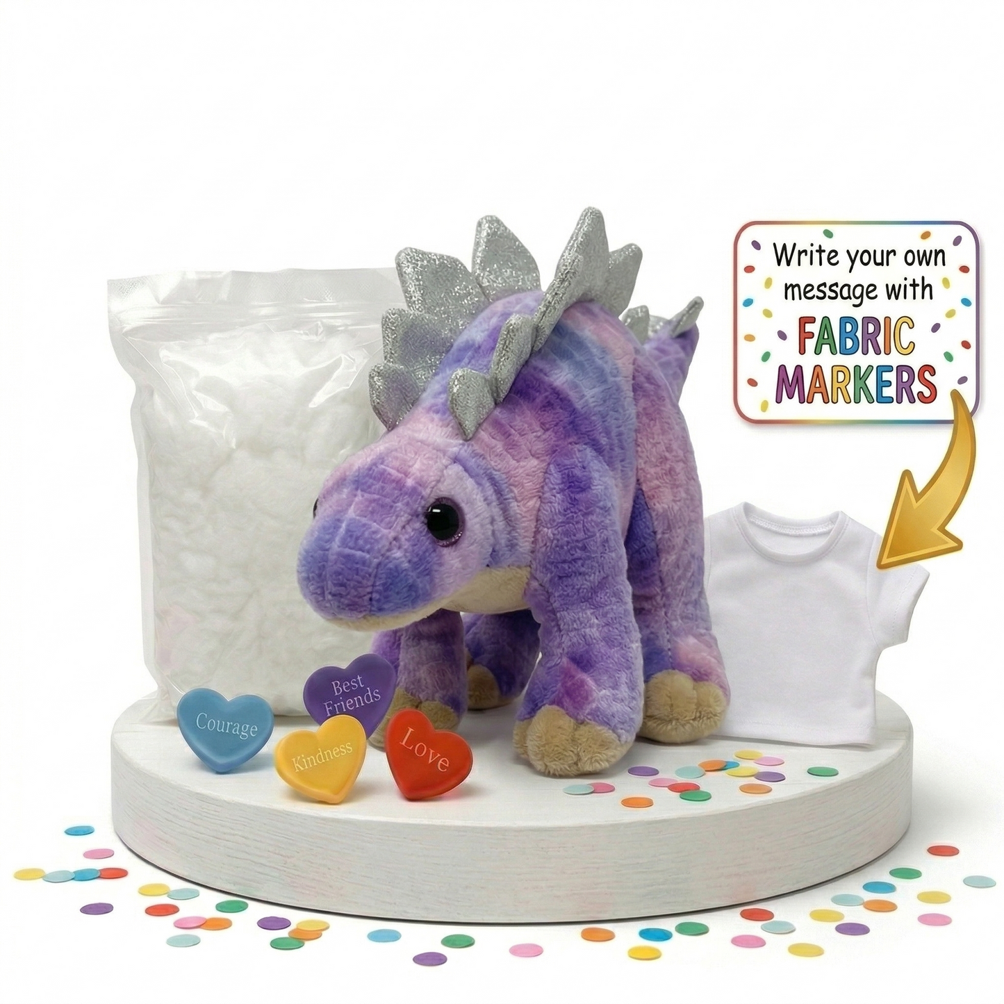 Purple dinosaur plush toy with fabric markers and a shirt on a white base with colorful confetti.